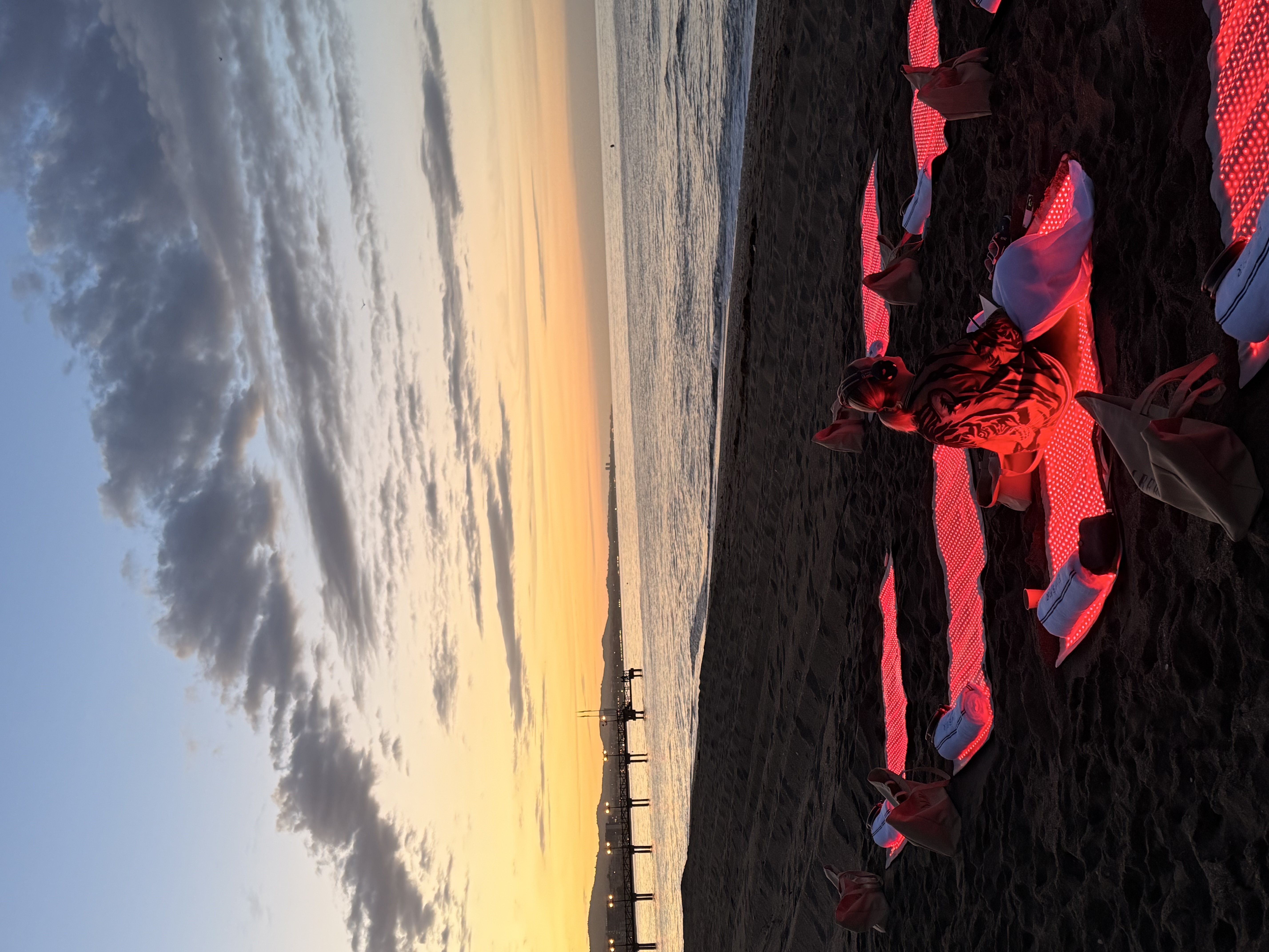 Ember Club sunrise on Marbella beach — red light therapy mats glowing at dawn